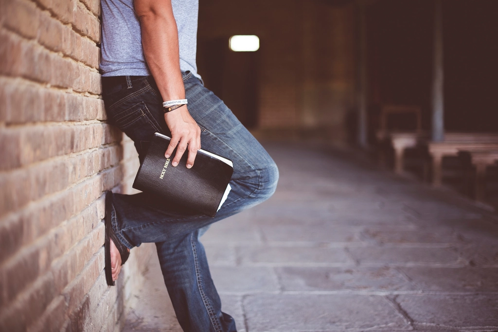 Man holding holy bible leaning